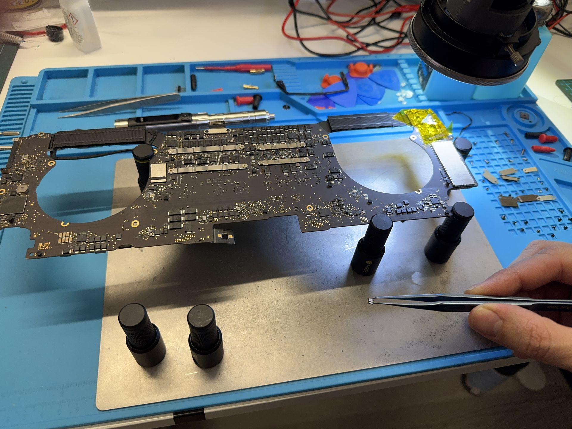 Motherboard from a Macbook Pro 2017 during repair with a desoldered transistor