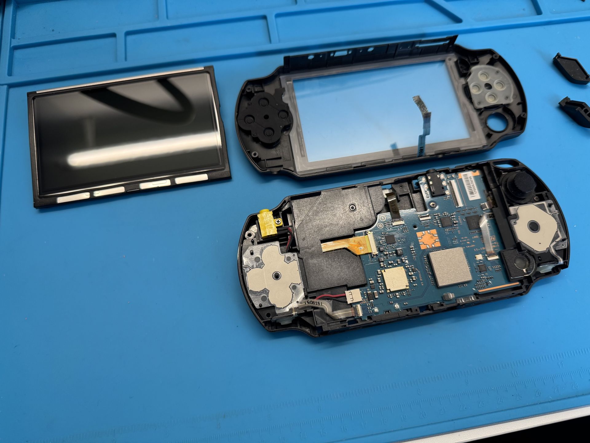 Disassembled PSP, front cover and display on the side
