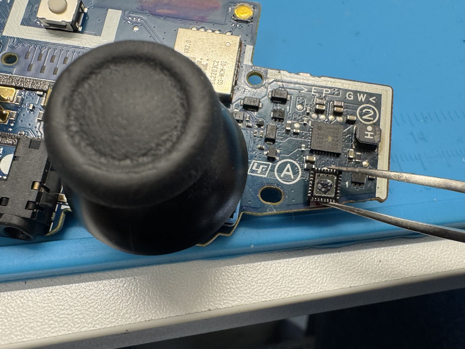A close-up view of the motherboard from a PS4 controller in the charging circuit area